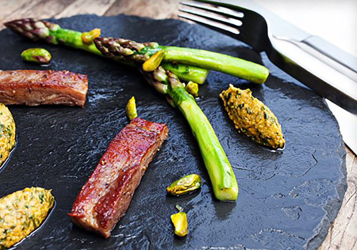 Panceta de cordero crujiente con chimichurri de pistacho y espárragos a la mantequilla